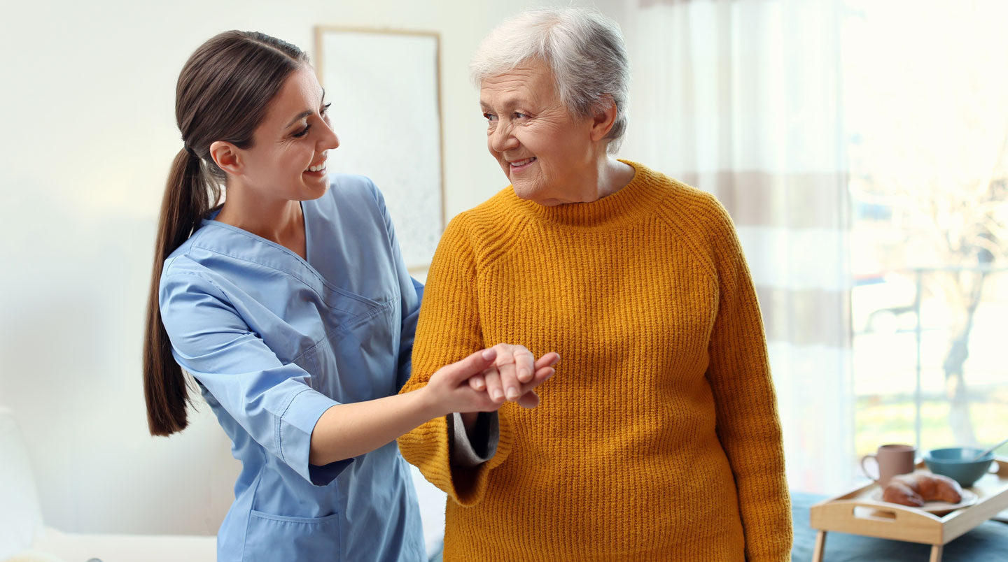 Médecin coordinateur effectuant une évaluation avec une personne âgée dans une salle de consultation EHPAD lumineuse, grille d'évaluation en main